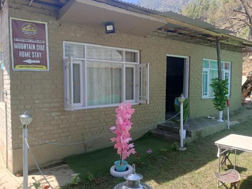 a small house with a sign on the side of it at Mountain side homestay in Pahalgām