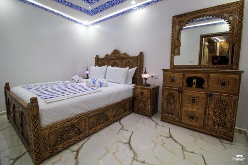 a bedroom with a bed with a mirror and a dresser at Casa Sanae in Chefchaouene