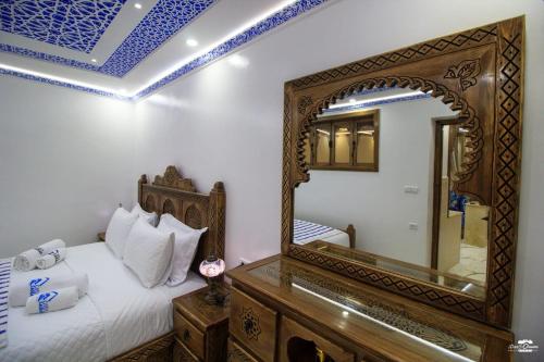 a bedroom with a mirror and a bed at Casa Sanae in Chefchaouene