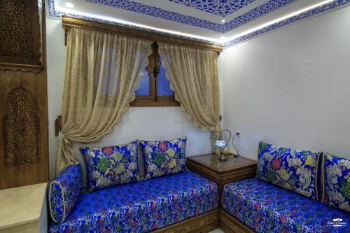 a blue couch in a room with a blue ceiling at Casa Sanae in Chefchaouene