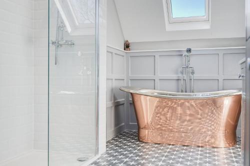 a bathroom with a copper tub and a shower at Northern Hideaways Oakfield Lodge, Ponteland in Newcastle upon Tyne
