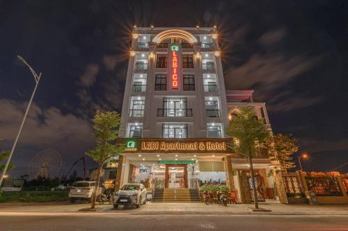 a tall building with a red sign on it at LaBi Hotel n Apartment Danang in Da Nang