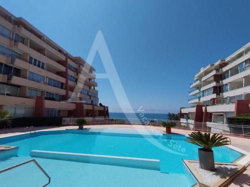 une piscine devant un immeuble dans l'établissement APPARTEMENT 1 CHAMBRE BORD DE MER, à Sète