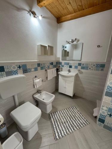 a bathroom with a white toilet and a sink at Villa Ninfa in Lampedusa