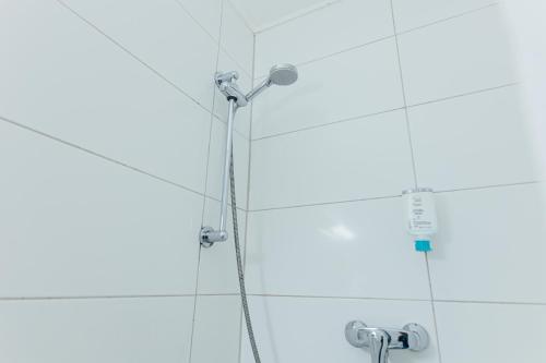 a shower with a shower head on a white wall at Hotel Commerz Hamburg in Hamburg