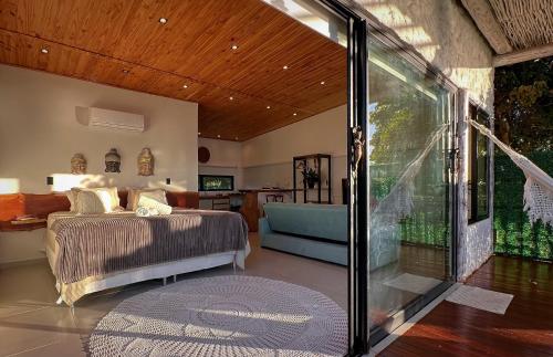 a bedroom with a bed and a sliding glass door at Pipa Sunset Villa in Pipa