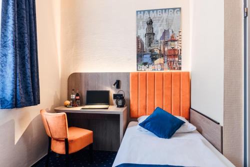 a room with a bed and a desk with a laptop at Hotel Commerz Hamburg in Hamburg