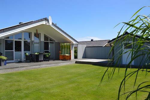 a house with a green lawn in front of it at Ferienhaus Nordseeluft in Wesselburenerkoog