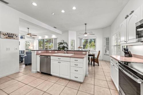 a kitchen with white cabinets and a counter top at Villa Champagne - 5322 in Siesta Key