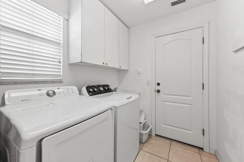 a white kitchen with a dishwasher and a white door at Villa Champagne - 5322 in Siesta Key