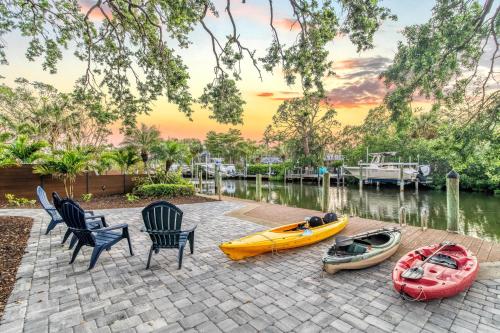 three kayaks and chairs on a patio next to a body of water at Villa Champagne - 5322 in Siesta Key