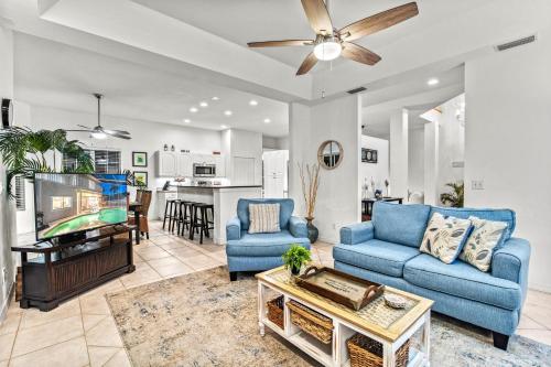 a living room with two blue couches and a tv at Villa Champagne - 5322 in Siesta Key