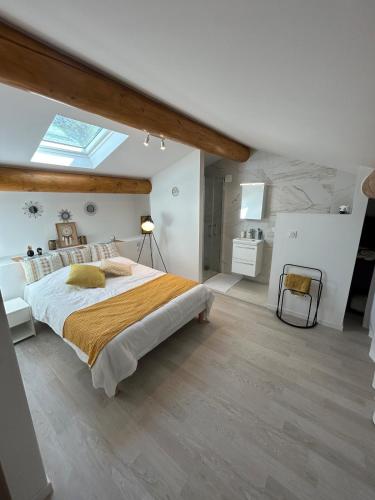 - une chambre avec un grand lit et une lucarne dans l'établissement Charmante maison avec piscine et grand jardin, à LʼIsle-sur-la-Sorgue