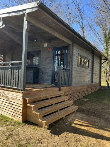 une petite maison avec une grande terrasse en bois dans l'établissement le domaine de la grande veyiere, à Molières