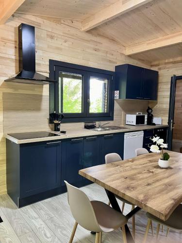 une cuisine avec des placards bleus et une table en bois dans l'établissement le domaine de la grande veyiere, à Molières