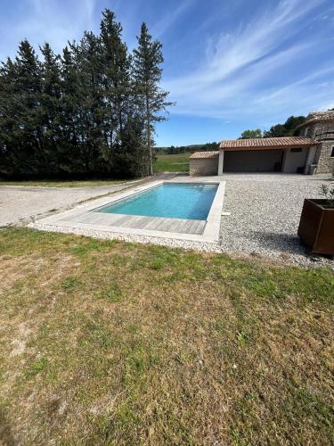 une piscine devant une maison dans l'établissement Charmante maison avec piscine et grand jardin, à LʼIsle-sur-la-Sorgue