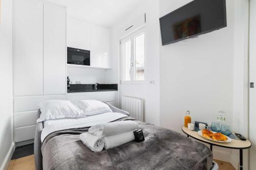 une chambre blanche avec un lit et une table dans l'établissement Studio cosy metro pereire paris 17 - 2P, à Paris