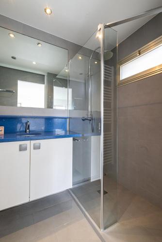 une salle de bain avec une douche en verre et un lavabo dans l'établissement Stunning apartment with sea front terrace, à Saint-Laurent-du-Var