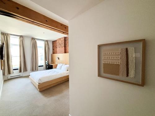 a bedroom with a bed and a picture on the wall at Queen Room at The Franklin Hotel Downtown on Water Street in St. John's