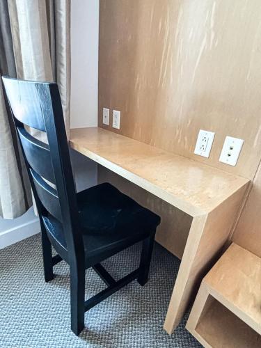 a black chair sitting next to a wooden desk at Queen Room at The Franklin Hotel Downtown on Water Street in St. John's