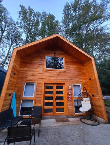 a small log cabin with a large roof at Casa Flores Verdes in Coñaripe