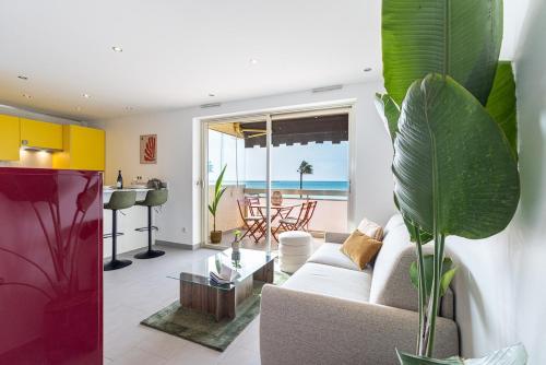 un salon avec un canapé blanc et une table dans l'établissement Stunning apartment with sea front terrace, à Saint-Laurent-du-Var