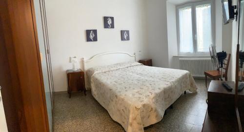 a bedroom with a bed and pictures on the wall at Domus Zoe in Forte dei Marmi