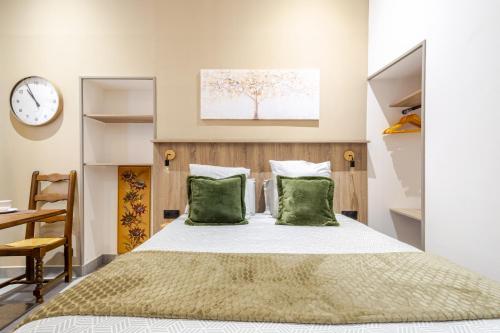a bedroom with a bed with two green pillows at Studio Luxe & Confort - Elegance Coeur de Béziers in Béziers