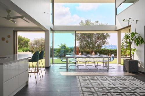 une cuisine et une salle à manger avec une table et une grande fenêtre dans l'établissement Cannes - Modern villa with 180° sea view, à Vallauris