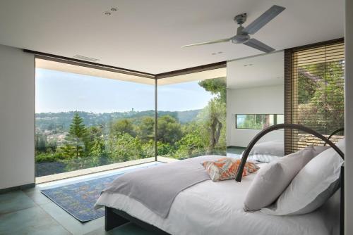 une chambre avec un lit et une grande fenêtre dans l'établissement Cannes - Modern villa with 180° sea view, à Vallauris