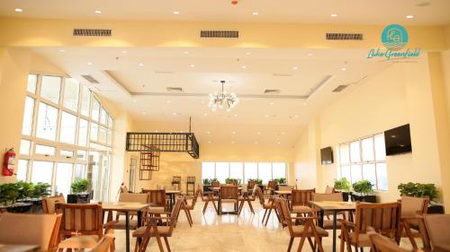 a restaurant with tables and chairs and windows at Lake Greenfield Hotel and Towers in Abuja