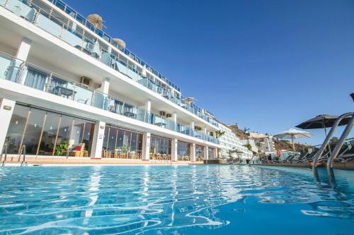 a swimming pool in front of a hotel at Servatur Casablanca Suites & Spa - Adults Only in Puerto Rico de Gran Canaria
