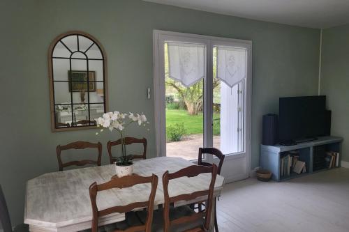 une salle à manger avec une table et une fenêtre dans l'établissement Maison à la campagne pour escapades touristiques !, à Nalliers