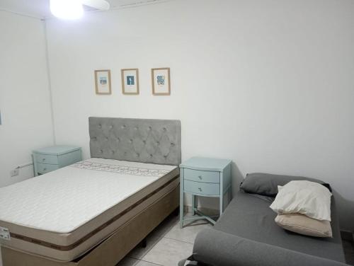 a bedroom with a bed and a bed and a couch at Família munhoz in Cananéia