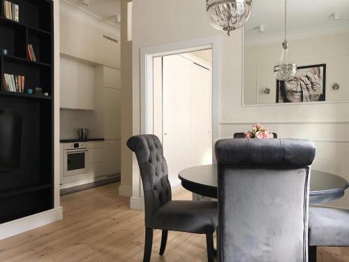 ソポトにあるVictus Apartamenty, Apartament Glamourのテーブルと椅子のあるキッチンとダイニングルーム