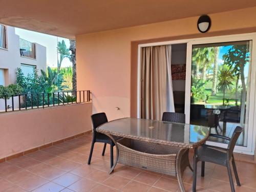 a dining room with a table and chairs on a balcony at Mar Menor Golf Resort, Fitnes, Tennis, wellness, Security! in Torre-Pacheco