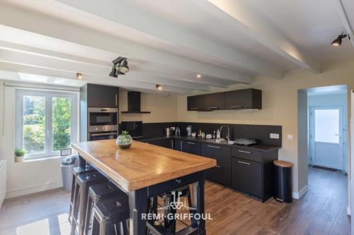 une cuisine avec des armoires noires et un comptoir en bois dans l'établissement La Maison Josélise 4 Family & Countryside 10 guests, à Pennedepie