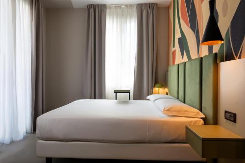 a bedroom with a large white bed in front of a window at Elite Hotel & Spa in Mestre