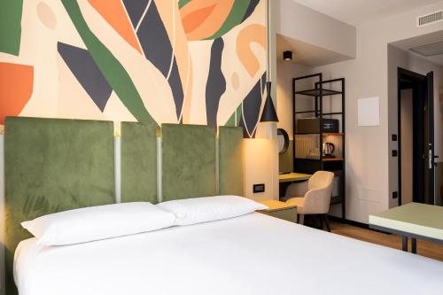 a bedroom with a white bed and a painting on the wall at Elite Hotel & Spa in Mestre