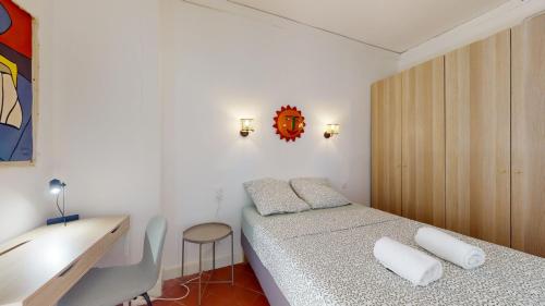 - une petite chambre avec un lit et un bureau dans l'établissement L'atelier de la rue Mailly, à Perpignan