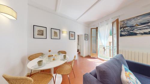 un salon avec une table et des chaises blanches dans l'établissement L'atelier de la rue Mailly, à Perpignan