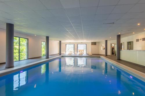 une piscine avec de l'eau bleue dans un immeuble dans l'établissement Les Balcons de l'Yse résidence de tourisme, à Luz-Saint-Sauveur