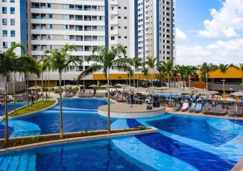a large swimming pool with palm trees and buildings at Apto em Olímpia- Enjoy Solar das Águas Park Resort in Olímpia