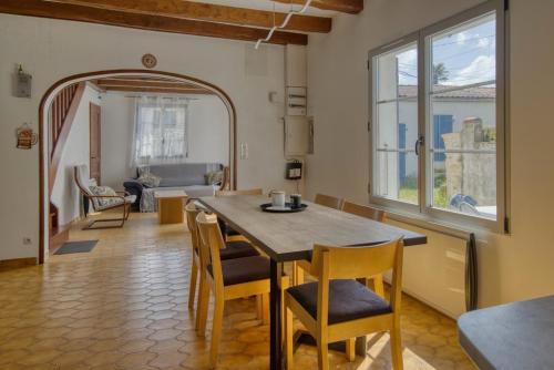une cuisine et une salle à manger avec une table et des chaises dans l'établissement Charme et confort à Domino PLAGE, à Saint-Georges-dʼOléron