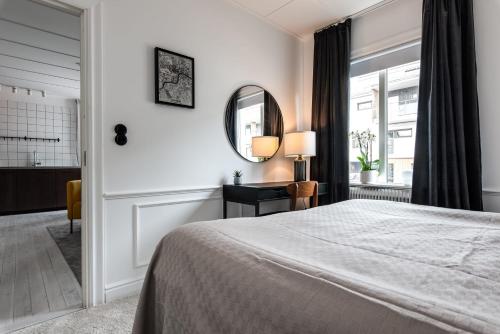 a bedroom with a large bed and a mirror at Luxurious apartment for the modern executive in Luleå