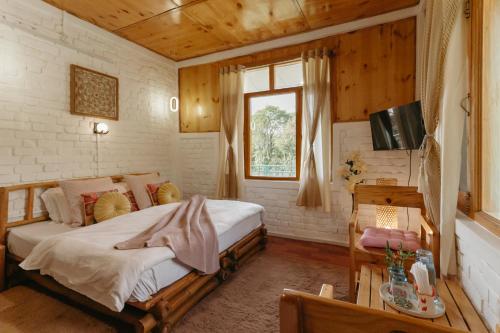 a bedroom with a bed and a window at The Hood in Bīr