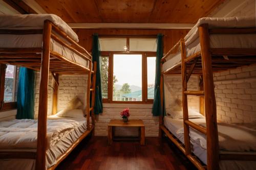 two bunk beds in a room with a window at The Hood in Bīr