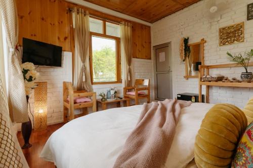 a bedroom with a white bed and a window at The Hood in Bīr