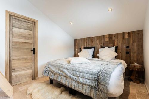 une chambre avec un grand lit avec une tête de lit en bois dans l'établissement Linea Loft - La Plagne Paradiski, à La Plagne Tarentaise