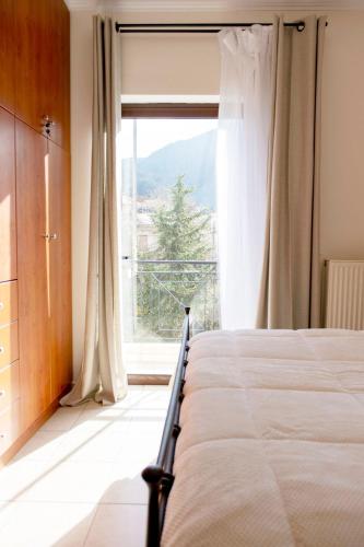 a bedroom with a bed and a large window at Rokani Studio I at Kalavrita Center in Kalavrita